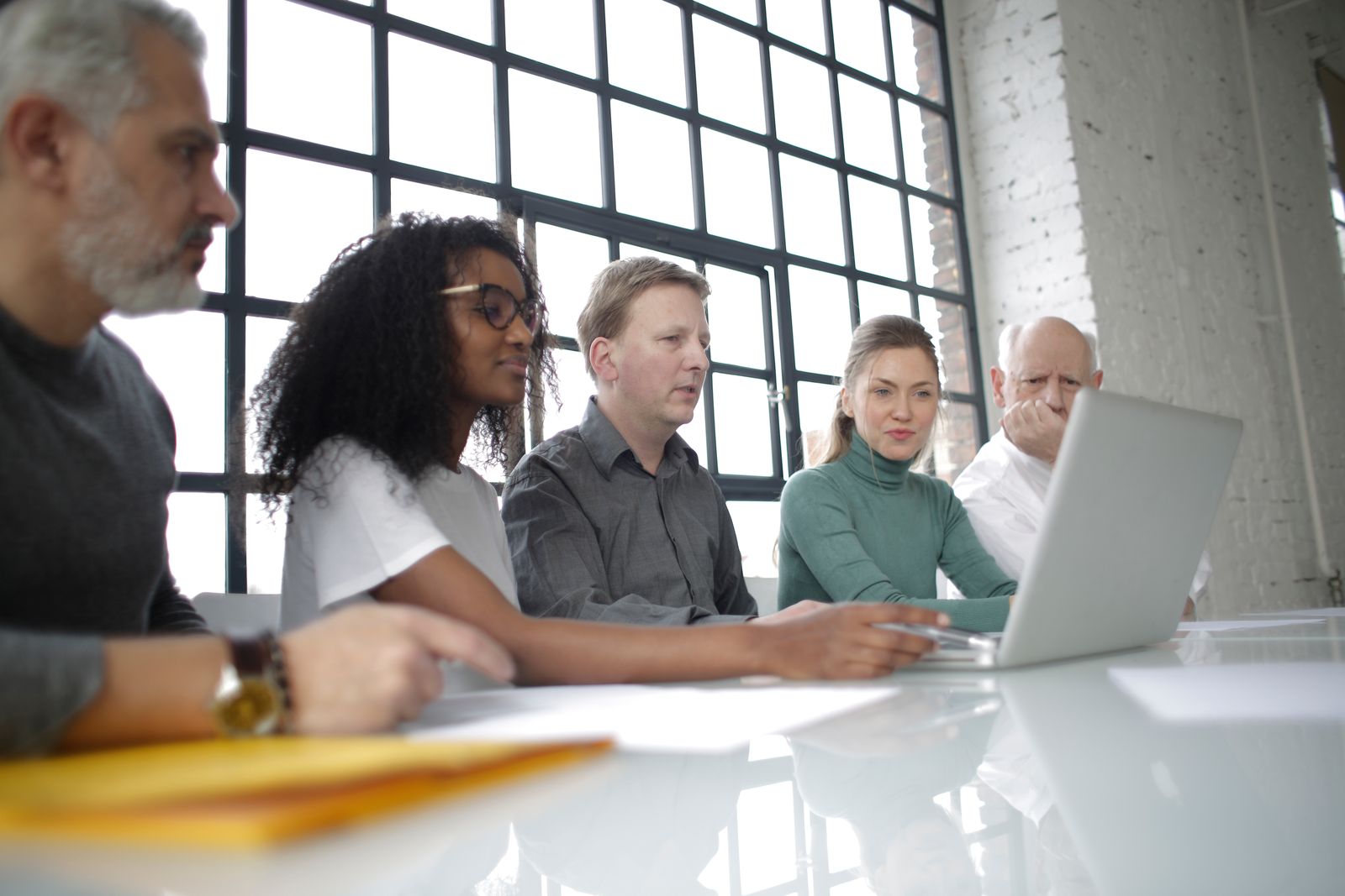 Consulting team reviewing software requirements around a laptop